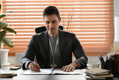 Empresário de terno trabalhando com computador no escritório moderno.