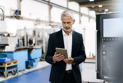 Imagem de um homem usando tablet digital em empresa de alta tecnologia