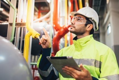 Engenheiro chefe controlando máquinas com tablet. Tecnologia e inovação na indústria.
