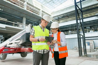 Retrato industrial de engenheiros masculinos e femininos na construção de prédio administrativo comercial