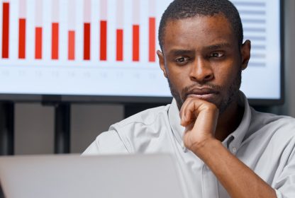 jovem empresário analisando um em seu computador