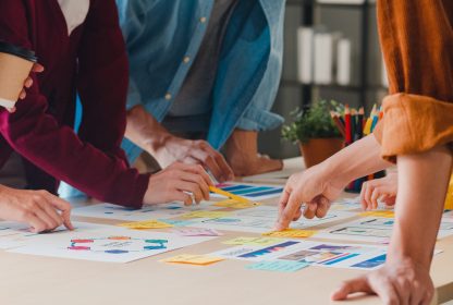 Workflow: colegas de trabalho analisam gráficos em uma mesa.